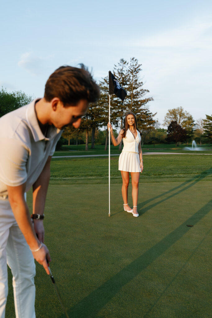 Couple playing golf during their engagement shoot at Lochmoor Golf Club