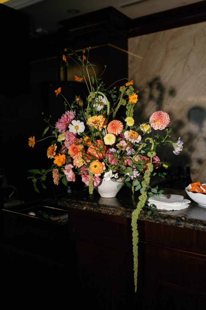Flash photo of floral arrangement seated on bar.