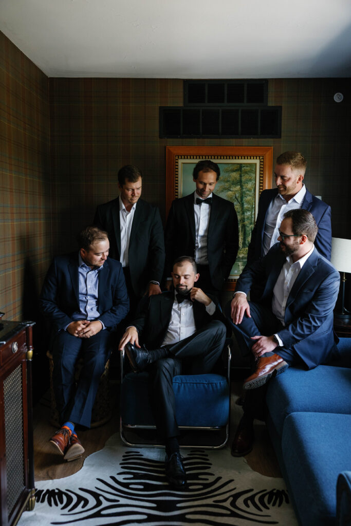 groom seated surrounded by groomsmen at the graduate hotel in Ann Arbor Michigan