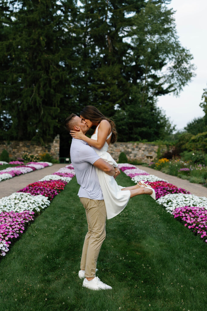 Playful lift and kiss during Detroit engagement session at Cranbrook House.