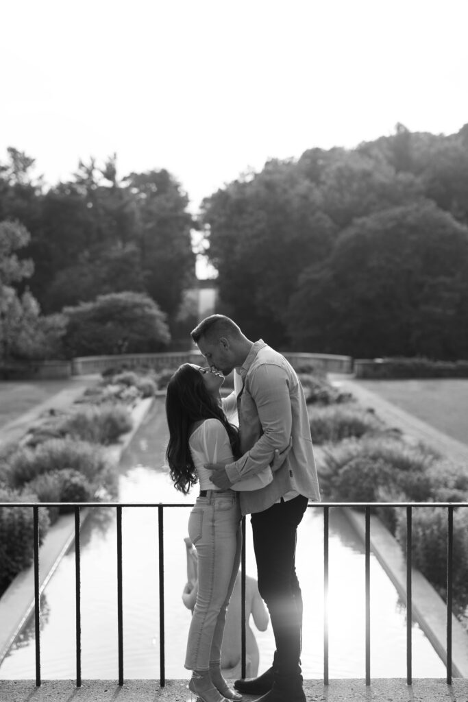 Black and white kiss on the balcony overlooking reflection pool at Cranbrook House & Gardens.