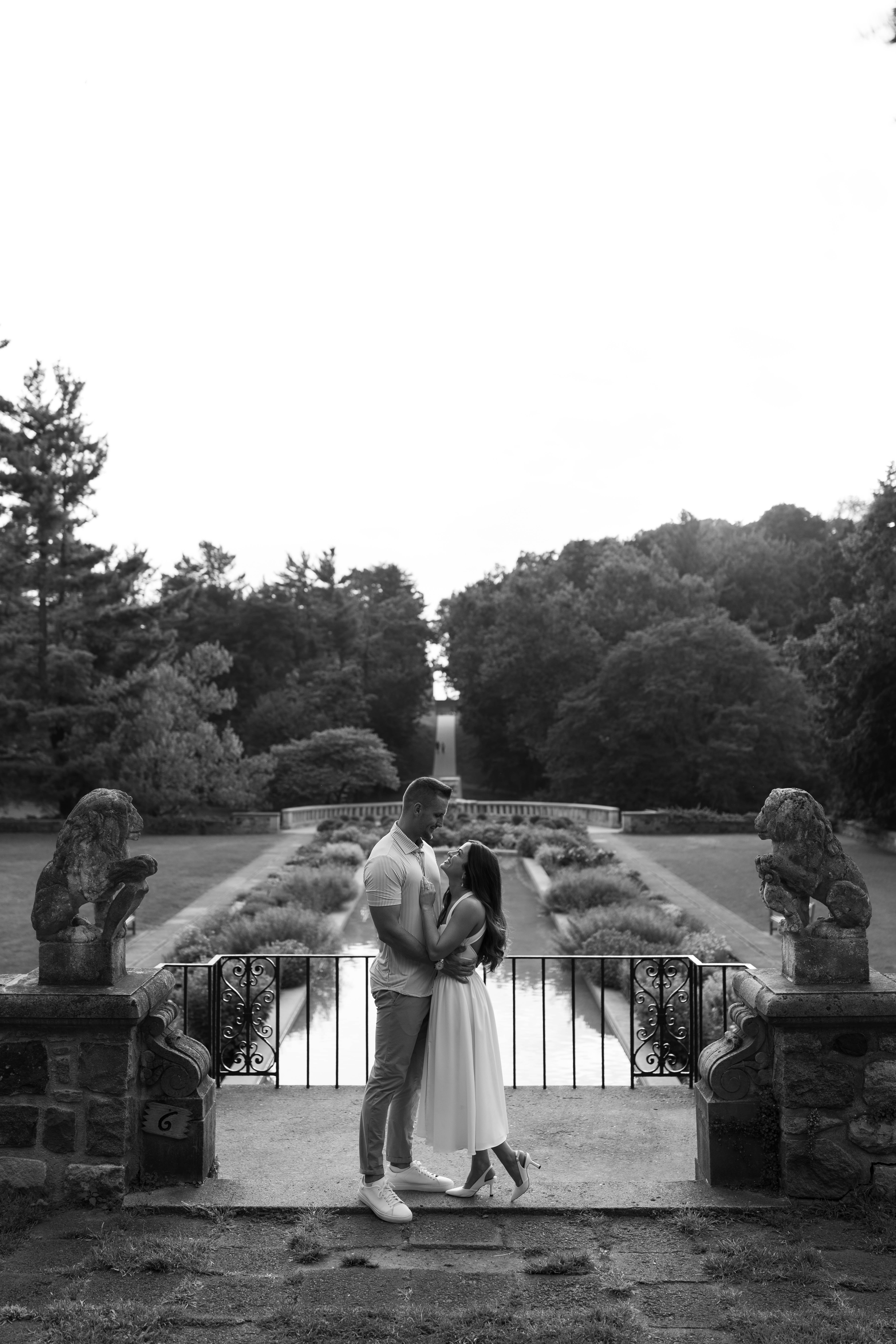 Black and white kiss on the balcony overlooking reflection pool at Cranbrook House & Gardens.