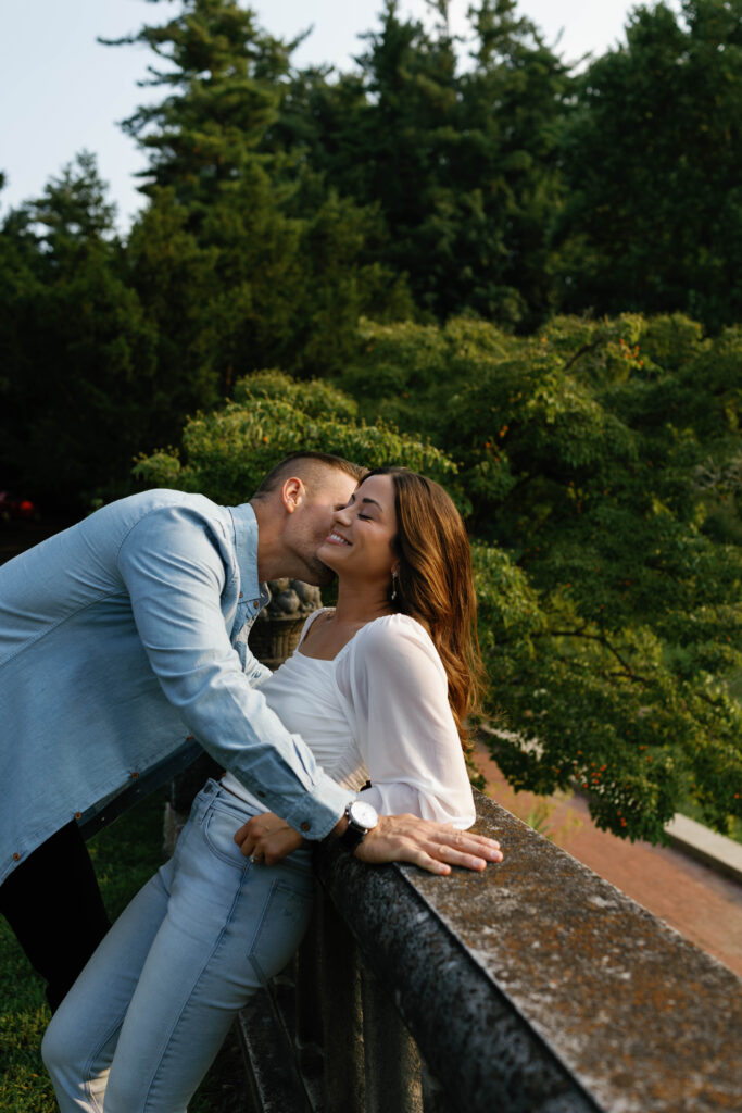 Romantic kiss on stone railing at Cranbrook House & Gardens in Detroit.