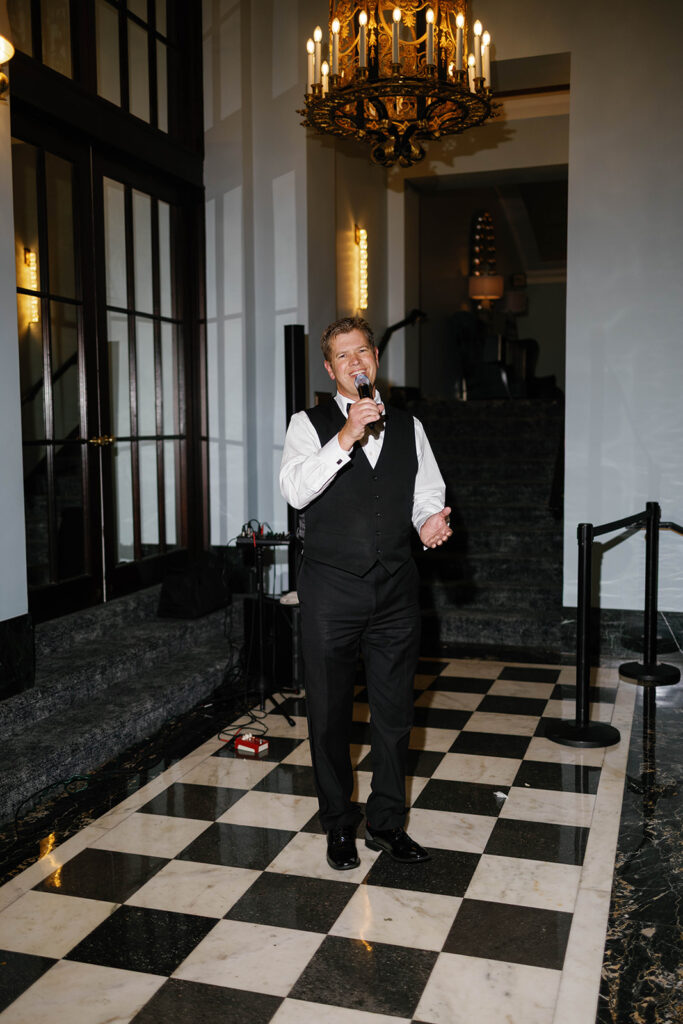 Live wedding singer at the Amway Grand Plaza wedding cocktail hour under a gold chandelier