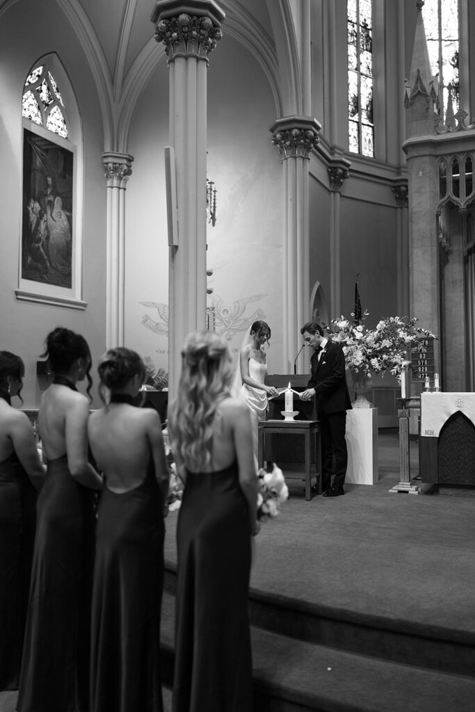 Bride and groom lighting unity candle during ceremony at St. Alphonsus Church in Grand Rapids before their Amway Grand Plaza wedding reception