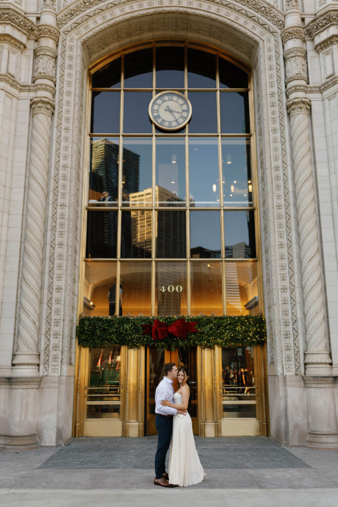 Chicago engagement photos groom kissing bride Wrigley Building iconic gold doors background