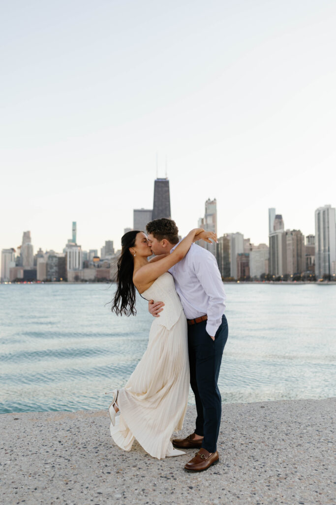 chicago engagement photos lakefront couple kissing with city skyline sunset