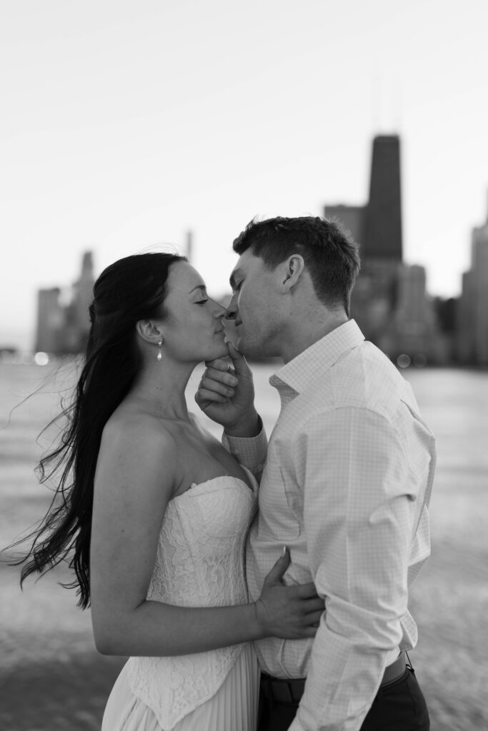 Lake Michigan Chicago engagement session romantic kiss skyline backdrop