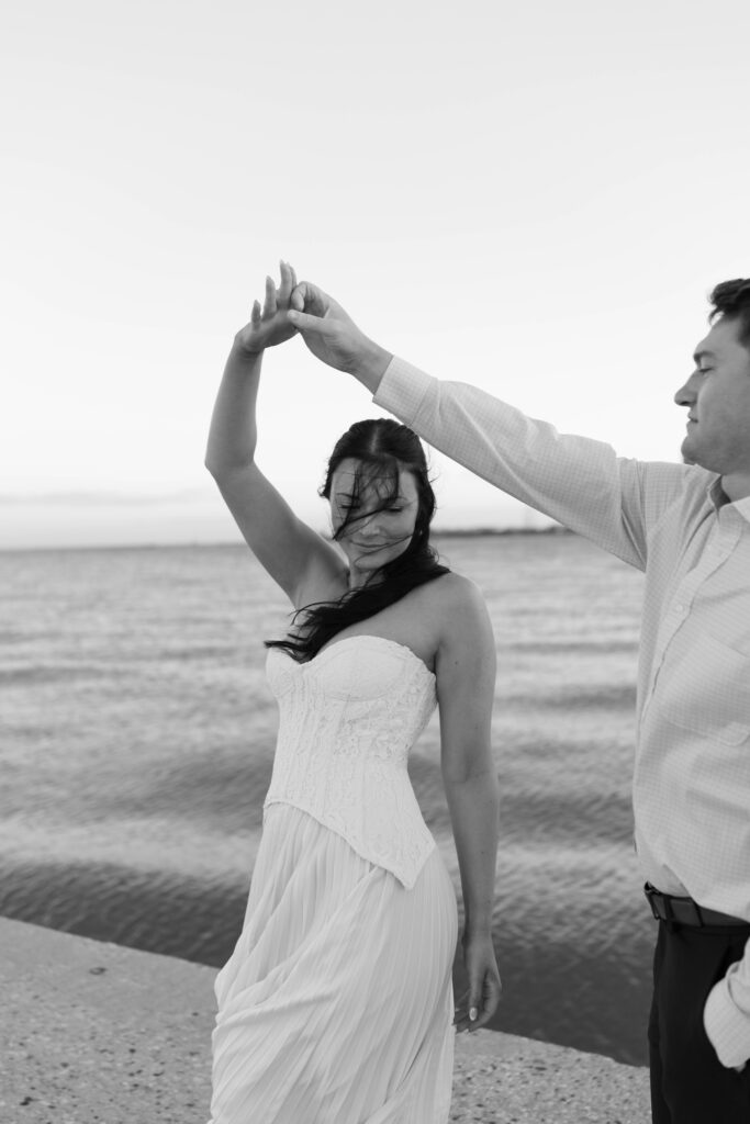 Chicago engagement photos Lake Michigan couple twirling with skyline background
